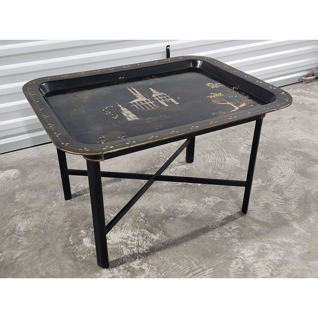 Vintage Chinoiserie style ebonized tray table with mother of pearl decoration and gilt trims. The stunning table has...