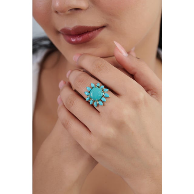 This vintage-style cocktail ring features a 6.7-carat natural mixed-cut turquoise, set in 14k yellow gold. The center...
