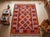 A handwoven Maimana kilim from northern Afghanistan in a full palette of madder red, burnt orange, indigo blue, ivory and...
