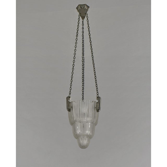 Marius Ernest Sabino A French 1925-1935 art deco pendant chandelier in nickel plated solid brass or bronze holding a...