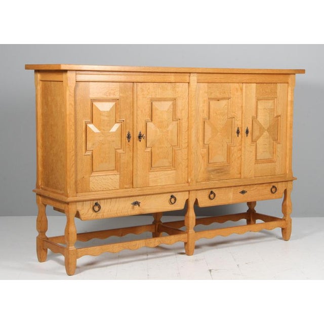 Striking highboard in oak with rich carved details. ByHenry Kjærnulf. Refreshing design with bold Baroque coming together...