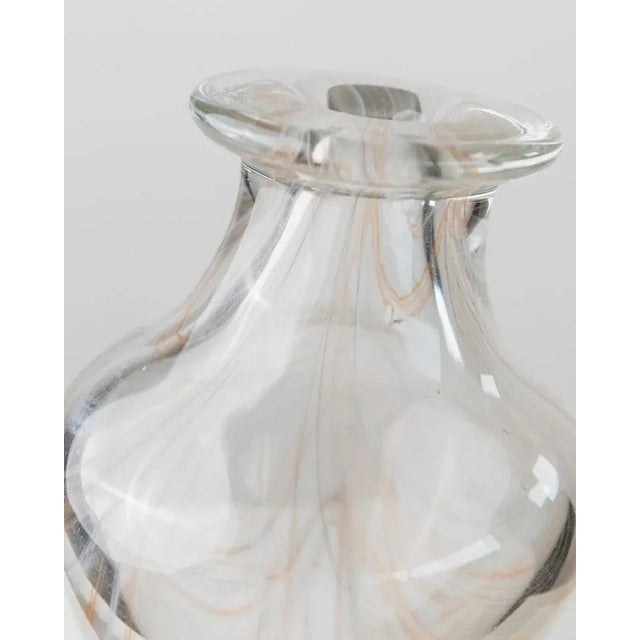 This vintage murano glass vase from the 1970s is a timeless piece of italian glass art, showcasing delicate swirls in...