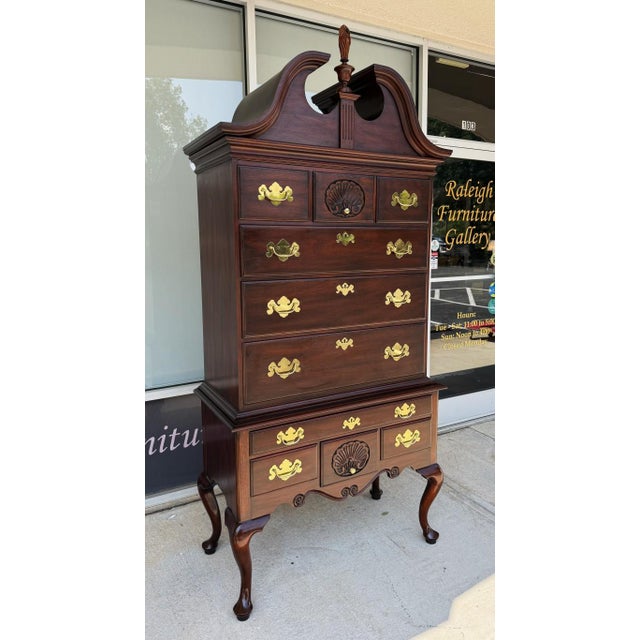 This Henkel Harris solid mahogany highboy, Models 145, 146, and 147, features abundant drawer storage, brass hardware,...