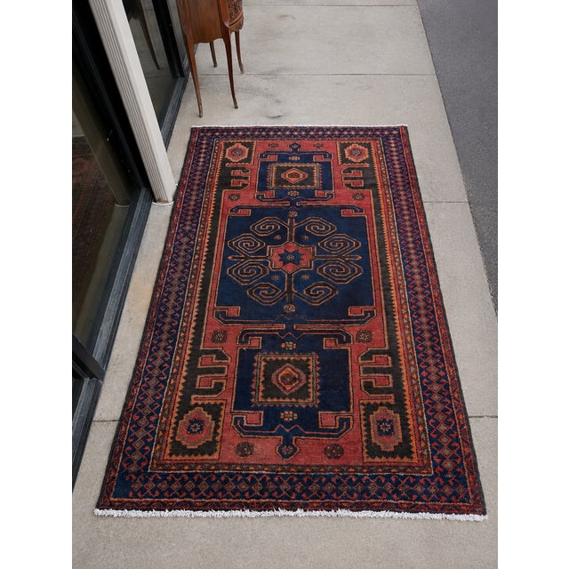 This is a mid-century hand knotted wool rug featuring a deep indigo field, madder red border, and bold geometric tribal...