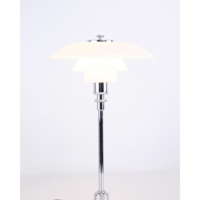 Classic ph 2/1 table lamp designed by poul henningsen and manufactured by louis poulsen. The lamp is made in chrome with...