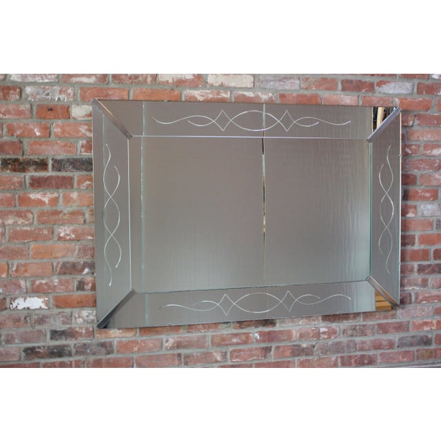 American decorator mirror (circa 1940s) composed of large beveled mirror with etched decoration throughout and polished...