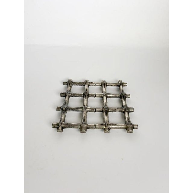 Decorative French metal table trivet featuring a sculptural openwork design inspired by interwoven bamboo canes. Its...