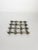 Decorative French metal table trivet featuring a sculptural openwork design inspired by interwoven bamboo canes. Its...