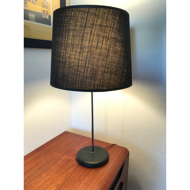 This chromed and black base table lamp with the original black shade is the epitome of clean and sleek mid century modern...
