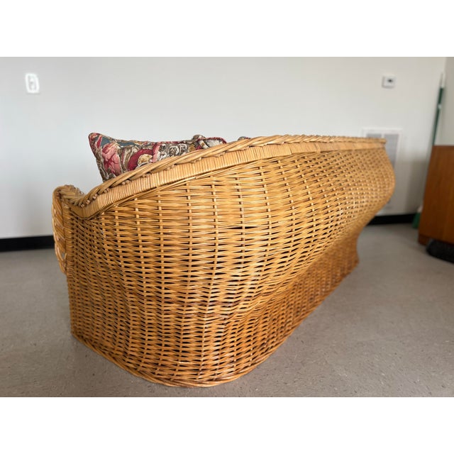 This vintage rattan sofa blends sculptural form, braided craftsmanship, and narrative textile art into one unforgettable...