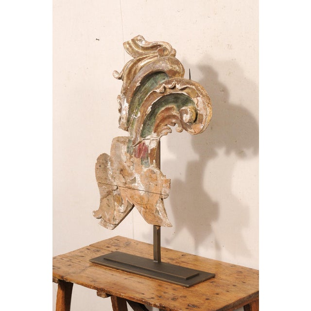 An Italian carved and gilt wood fragment from the 18th century, presented on custom stand. This antique decoration from...