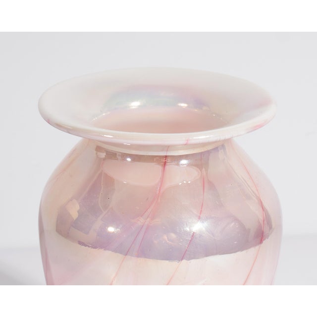 A 1990 glass vase by Gibson Glass. This vase is made from an iridescent pink and white glass with a feather-pulled design...