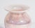 A 1990 glass vase by Gibson Glass. This vase is made from an iridescent pink and white glass with a feather-pulled design...