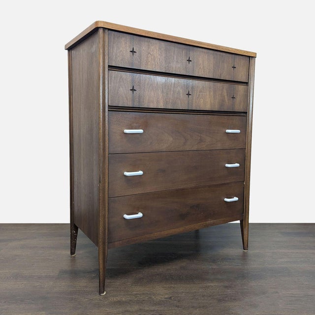 This Broyhill dresser features a classic mid-century modern design with clean lines and stylish metal handles. It offers...