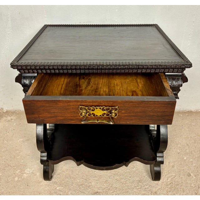 Elegant Portuguese side table featuring a single drawer, decorative carved details, and a shaped lower shelf. The table...