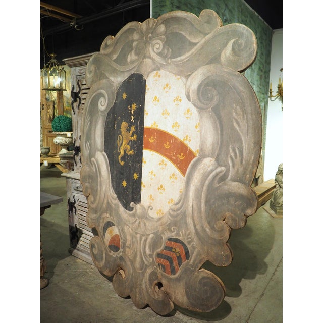 Constructed from salvaged antique wood that has been reinforced with more recent boards, this large-scale coat of arms...