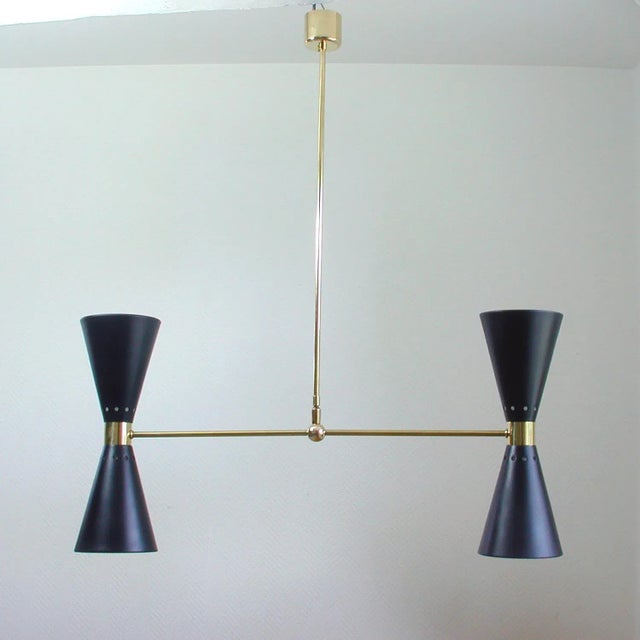 This elegant double cone chandelier was manufactured in France in the 1950s. It is made of brass and has got two black...