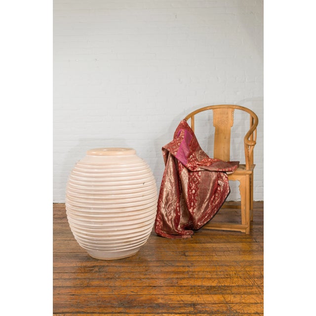 A large vintage Thai vase from the mid 20th century, with graduated line design and cream color with pink undertone....
