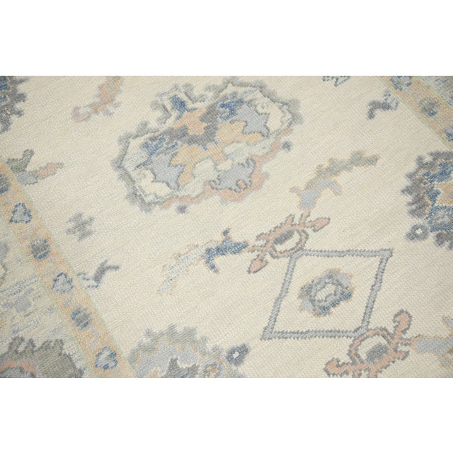 This modern Turkish Oushak rug is a stunning piece of art that has been handwoven using traditional techniques by skilled...