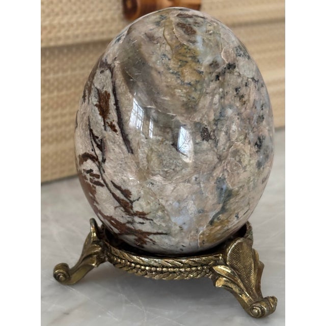 Vintage patinated brass stand with scroll feet holding a 3" tall jasper stone egg. Exquisite color and form to add to your...