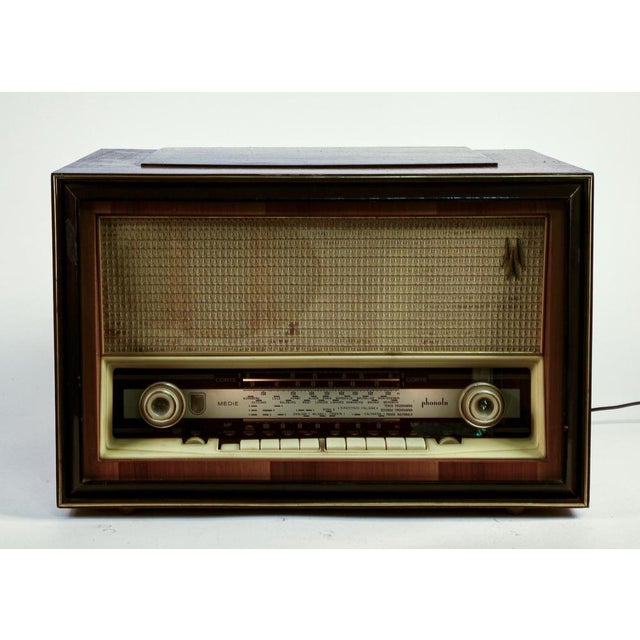 70s radio implected in mahogany and plastic details. Phonola company model 824 s. The radio lights up as an inserted...