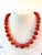 Gorgeous coral beaded necklace with 13 mm beads and gold tone clasp design designed by Matthew Izzo.