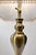 Elegant vintage table lamp featuring a sculptural brass-tone metal base with a beautifully shaped traditional silhouette....