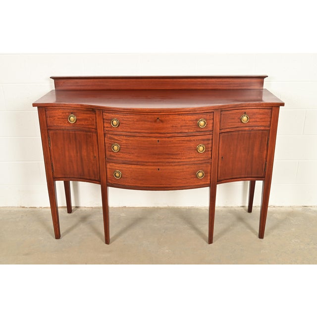 A gorgeous Federal or Hepplewhite style serpentine front sideboard buffet or credenza In the manner of Baker Furniture...
