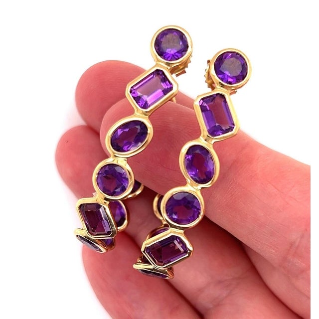 The product is a pair of vintage Amethyst Oval Bezel Set 18k Yellow Gold Inside Out Hoop Earrings. These original fine...