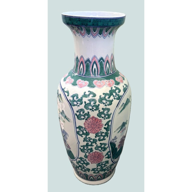 A striking 24-inch porcelain floor vase featuring an intricate hand‑painted landscape scene with mountains, trees, and...