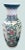 A striking 24-inch porcelain floor vase featuring an intricate hand‑painted landscape scene with mountains, trees, and...