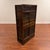 A richly patinated Japanese wooden storage cabinet featuring textured glass sliding doors, staggered display shelves, and...