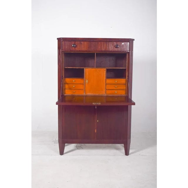 Abattant" desk. It has an austere, Biedermeier-inspired aesthetic, made from dark wood with a polished finish and a...