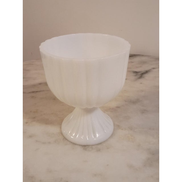 Pretty mid-century milk glass pedestal bowl with a ribbed body, fluted foot, and a delicate scalloped edge. Glossy white...