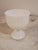Pretty mid-century milk glass pedestal bowl with a ribbed body, fluted foot, and a delicate scalloped edge. Glossy white...