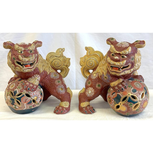 Ornate pair of vintage Kutani foo dogs. The incredibly detailed pair are made of Japanese pottery with a matte finish in...