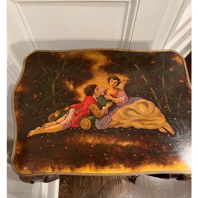Gorgeous French style table with painted scene on top. Brass accents. 30” tall. Great accent table.