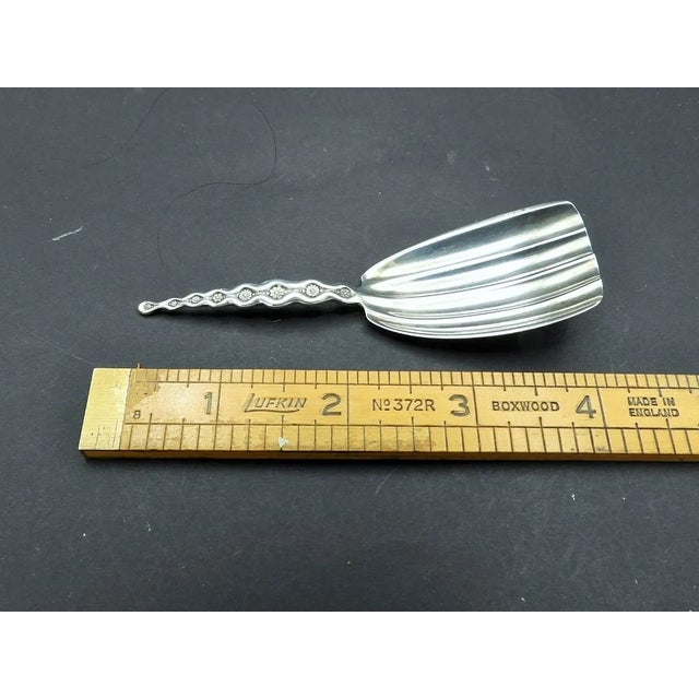 This marvelous Art Nouveau style tea caddy spoon is created in gorgeous sterling silver and was made by Whiting...