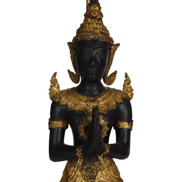 This is a pair of antique Thai lacquered and gilt bronze figural table lamps, depicting Teppanom guardian angels. Each...