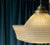 A striking mid-century American pendant light featuring a substantial molded glass shade with a distinctive combination of...
