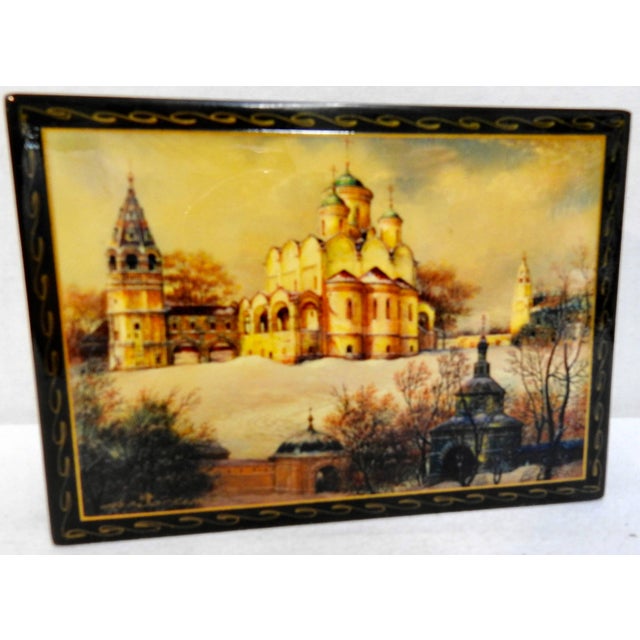 A snow scene surrounds the elaborate Annunciation Cathedral located near the Kremlin on this Russian black lacquer box....