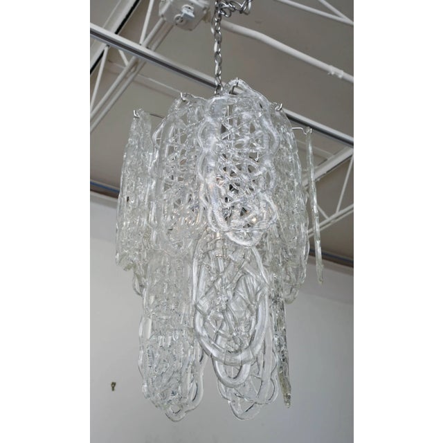 This gorgeous Italian Murano Mazzega chandelier has 15 white pretzel form fused glass pendants hanging to create an...
