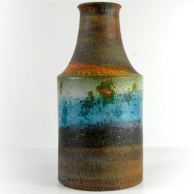 A large, massive ceramic vase adorned with decorative textured glazes in several colors. Designed and crafted in Italy by...
