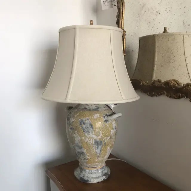 Ceramic urn shaped lamp with handles featuring a yellow crackle finish and 16 inch linen shade.
