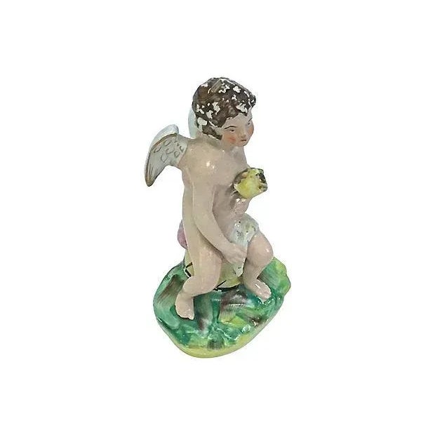 Antique; 19th century, English, Staffordshire, hand-painted, porcelain, cherub figurine depicted sitting on a drum and...