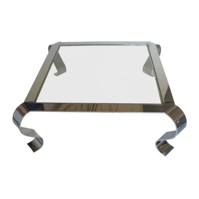 An elegant mid century modern square coffee table. Chrome frame with curved legs and glass insert top.