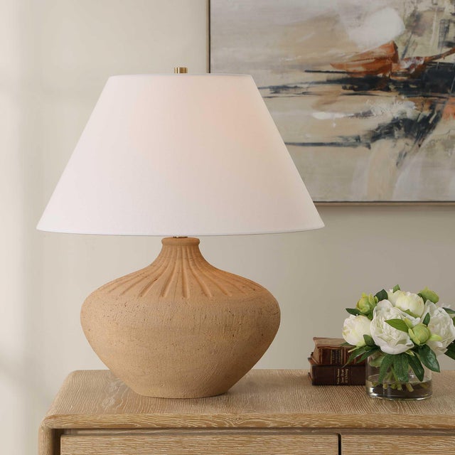 This Table Lamp Showcases An Urn Shaped Terracotta Base In A Warm Earthy Tone, Accented With Decorative Carvings And...