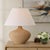 This Table Lamp Showcases An Urn Shaped Terracotta Base In A Warm Earthy Tone, Accented With Decorative Carvings And...