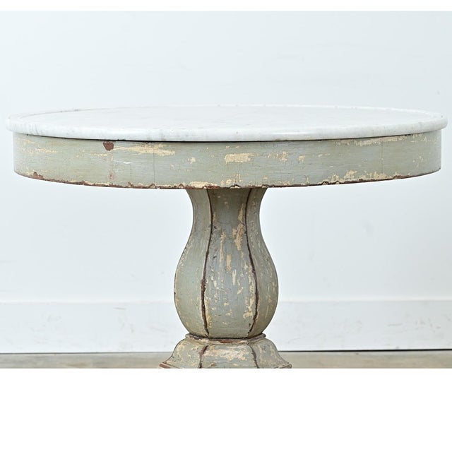 A lovely 19th-century French Restauration gueridon table with a marble top and a mahogany base. The stone has light grey...