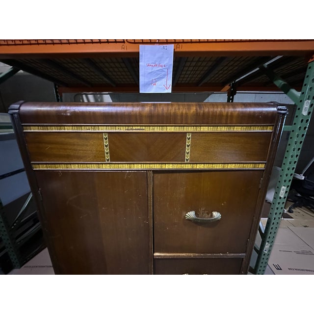Art Deco wardrobe in mahogany with detailed inlays. Have hanging clothes bar, open cabinet and 3 drawers. The size is 36”...